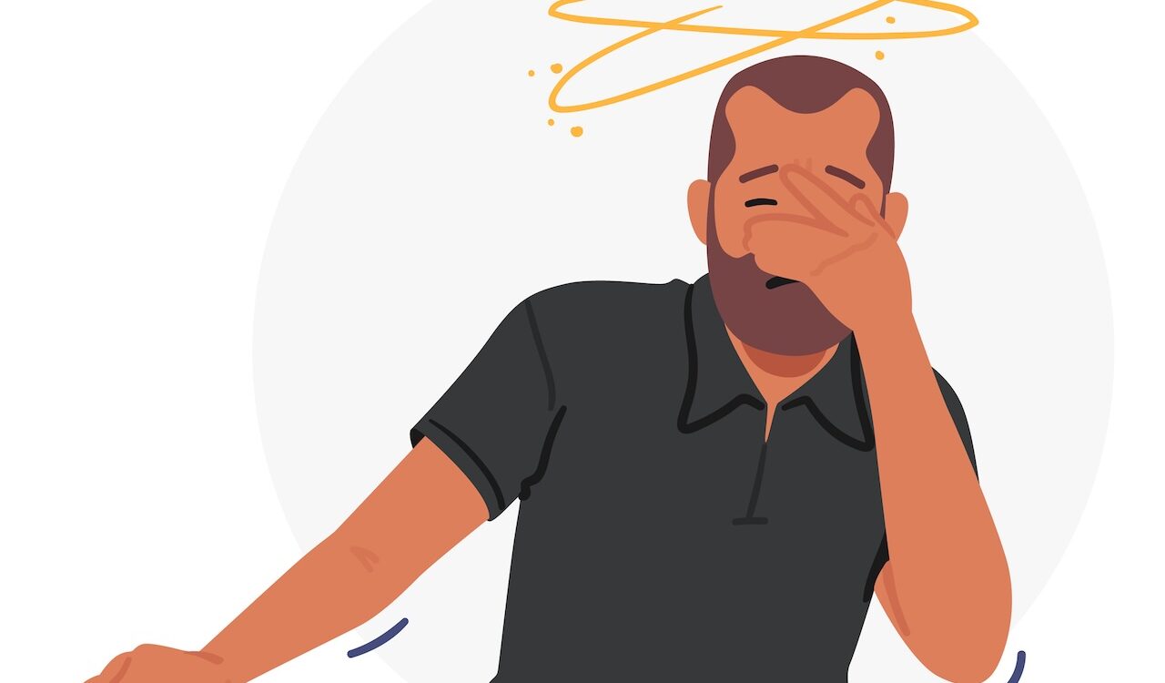 Man clutches his face and is dizzy