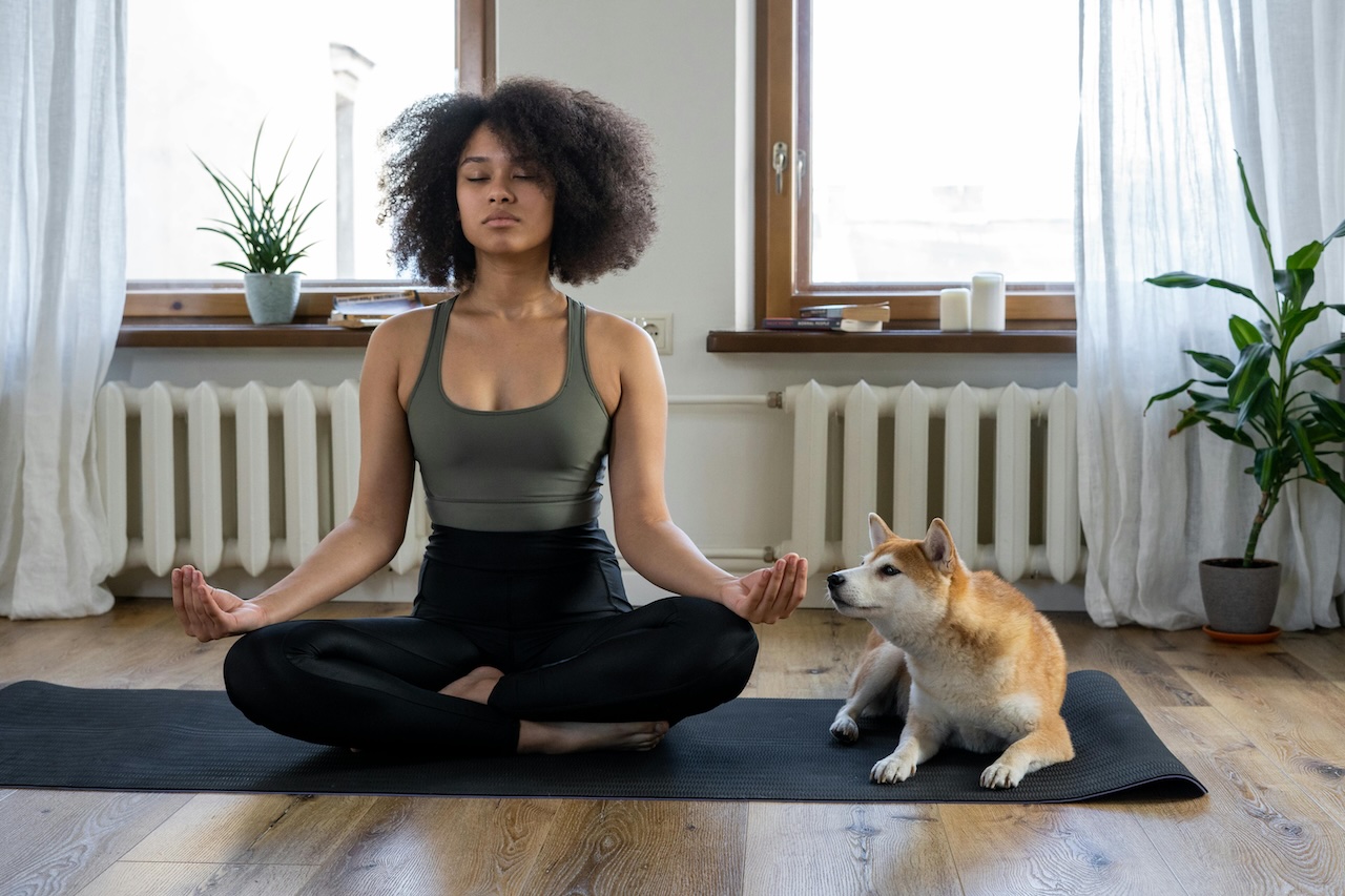 Woman and dog on yoga mat