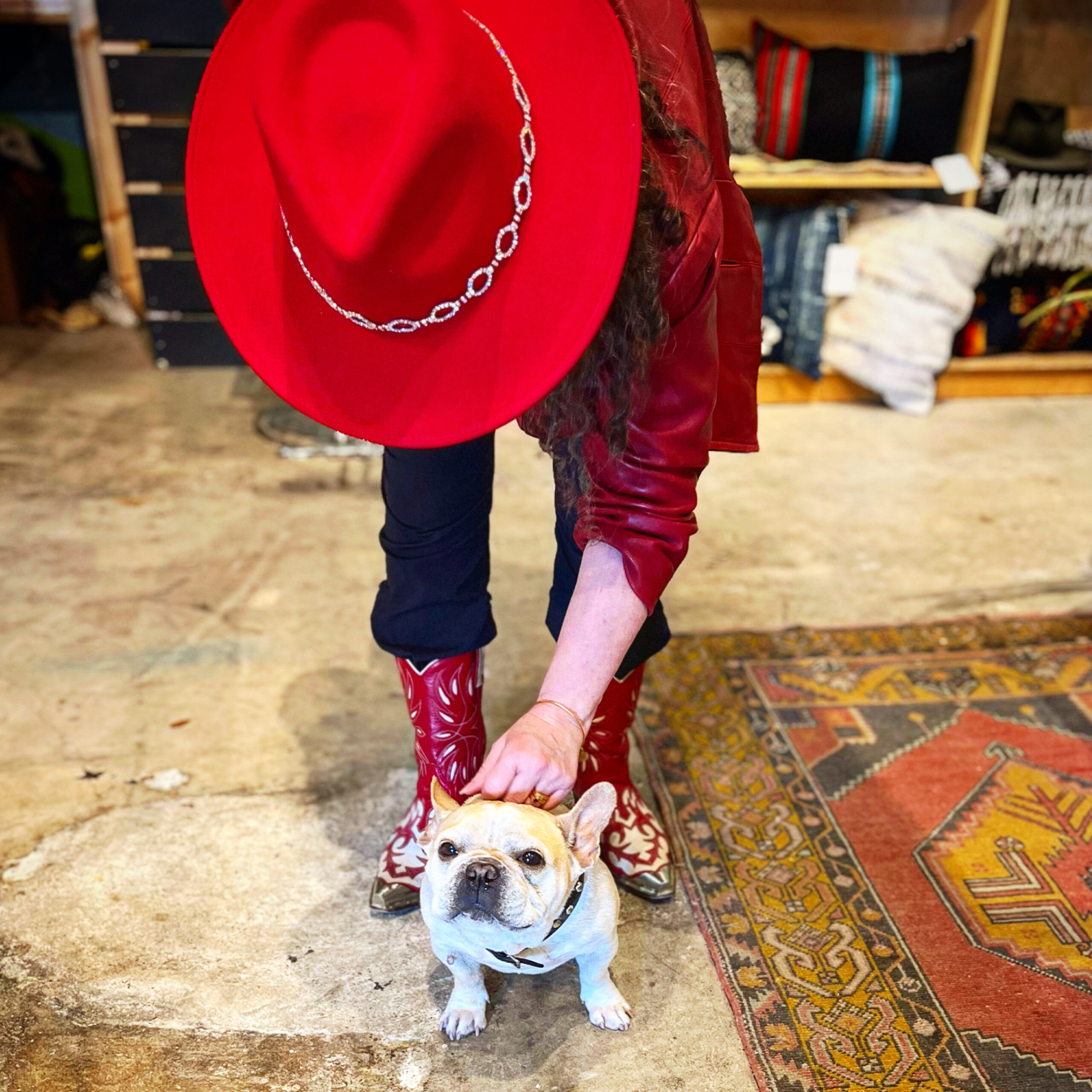 Dori in a red hat petting a dog